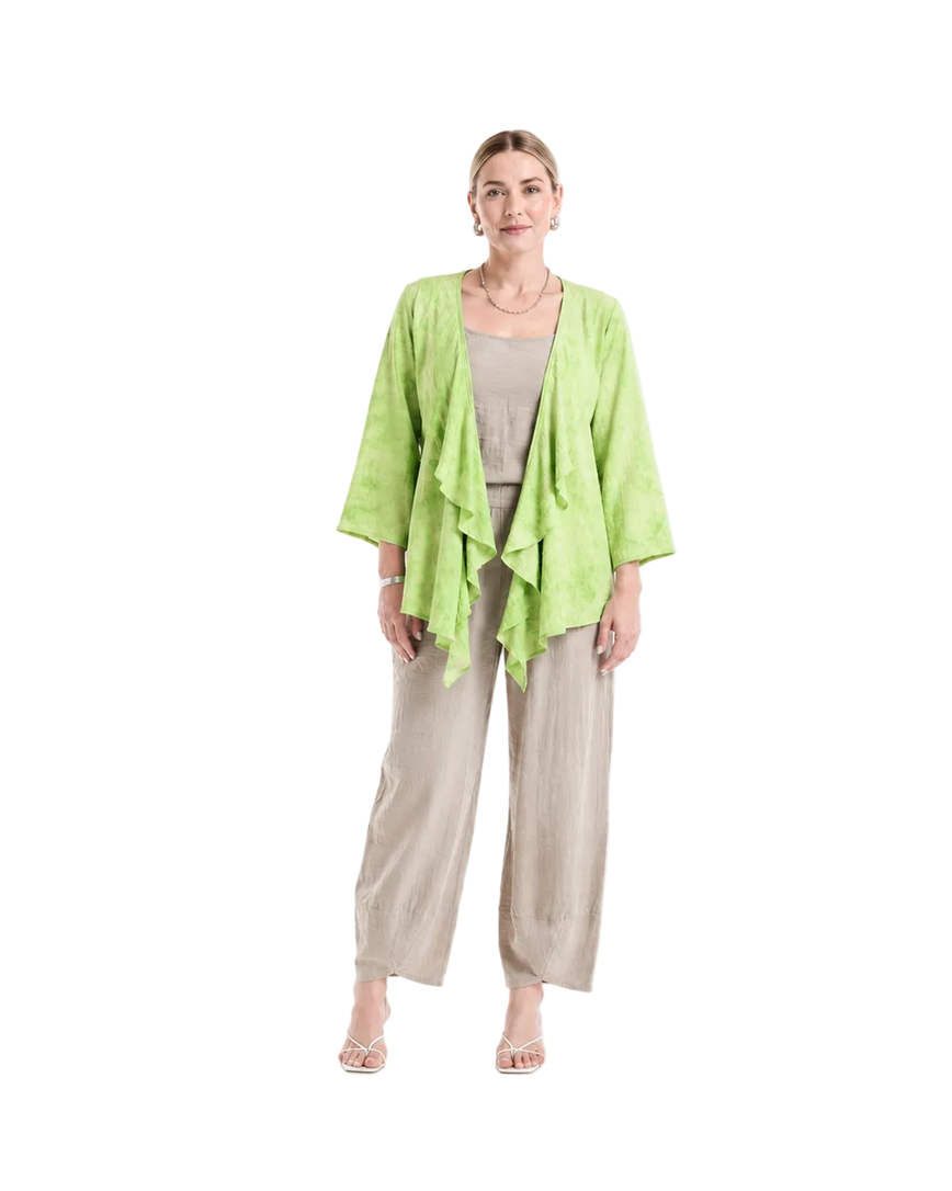 A woman modeling a light lime green open-front cardigan over a beige top and wide-leg beige pants, standing against a plain white studio background.