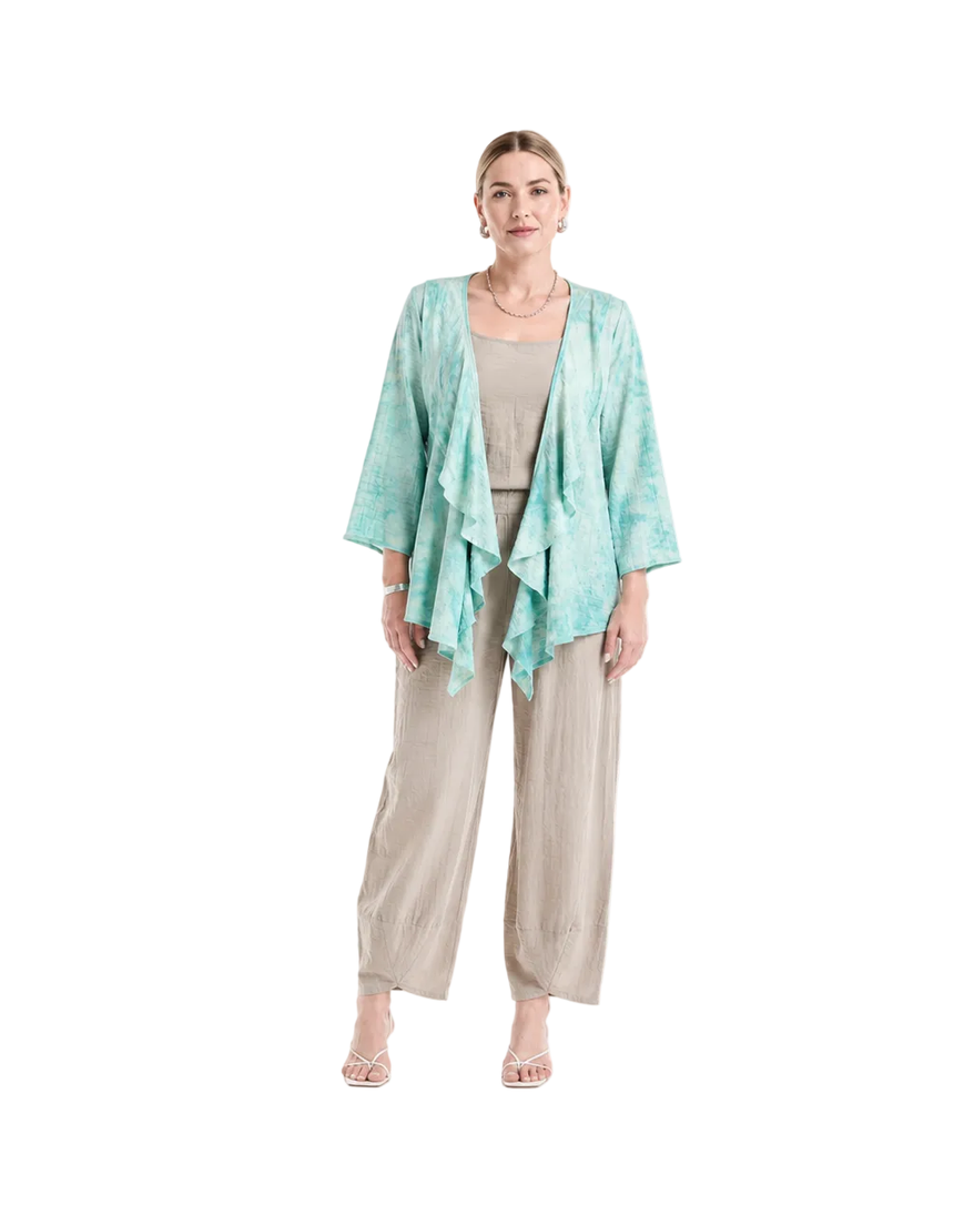 A woman modeling a light aqua and mint tie-dye open-front kimono cardigan over a beige top and wide-leg beige pants, standing against a plain white studio background.